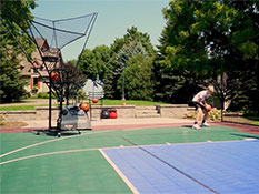 A kid practicing basketball at his own backyard with the help of a Dr Dish shooting machine
