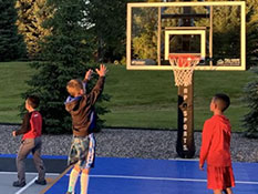 Kids playing a basketball game at their own backyard