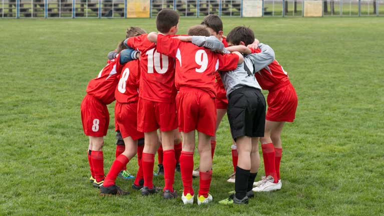 Kids team huddle during an outdoor game