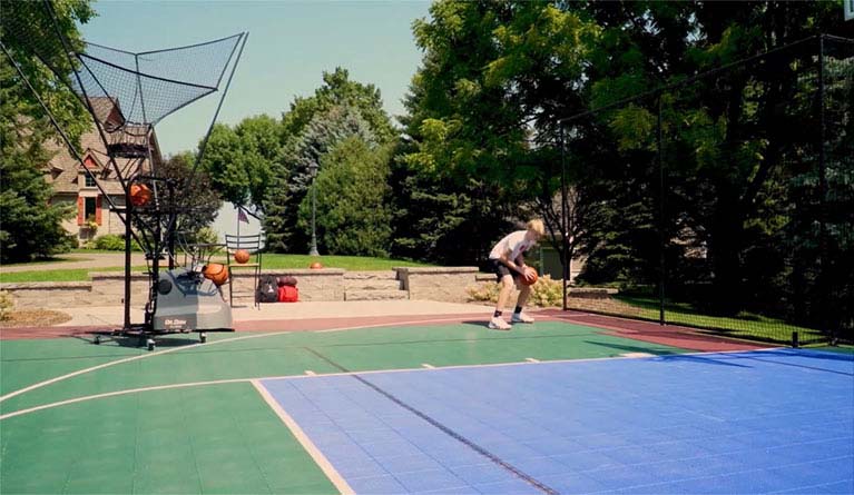 A basketball shooting machine assisting a kid at his own backyard