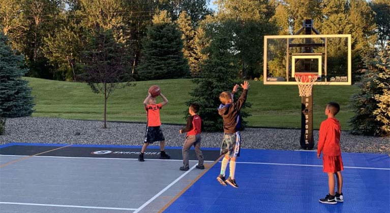 Kids playing basketball at their backyard court