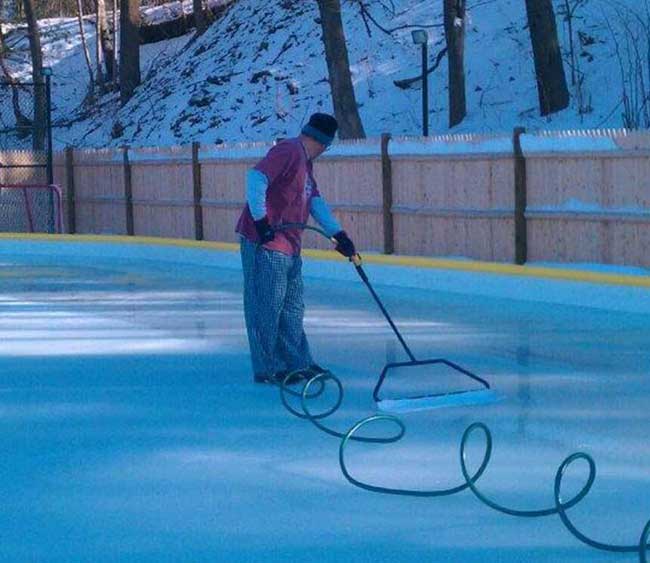 Man smoothing an ice rink surface with a 32 inches NiceIce™ Resurfacer