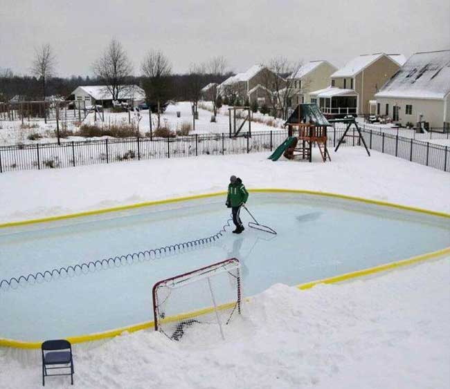 Man smoothing a a 20x40 backyard ice rink surface with a 52 inches NiceIce™ Resurfacer