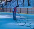 Man smoothing an ice rink surface with a 32 inches NiceIce™ Resurfacer