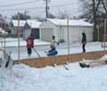 Kids playing hockey at their backyard rink built using the Rink in a Box kit