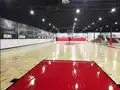 Junckers hardwood basketball court at Playground Burlington, Ontario with red key zones and full court lines.