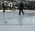 A team of people working on resurfacing a large outdoor ice rink