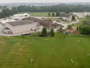 Empty grass field before outdoor multigame court installation at St. John's-Kilmarnock School Breslau