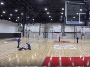 Total Sport Solutions installation crew working on the expansive hardwood court surfaces at Shoot 360 Oakville.