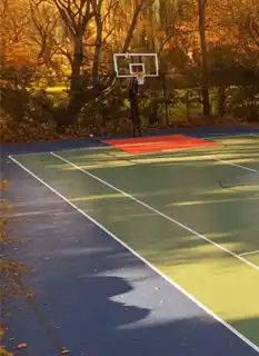 modular backyard basketball court in Toronto during fall with autumn leaves showing year-round durability and readiness for early spring play