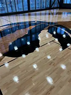 Full NBA-sized Junckers UnoBat 45 hardwood basketball court with custom chevron pattern at Sloane Building, North York.