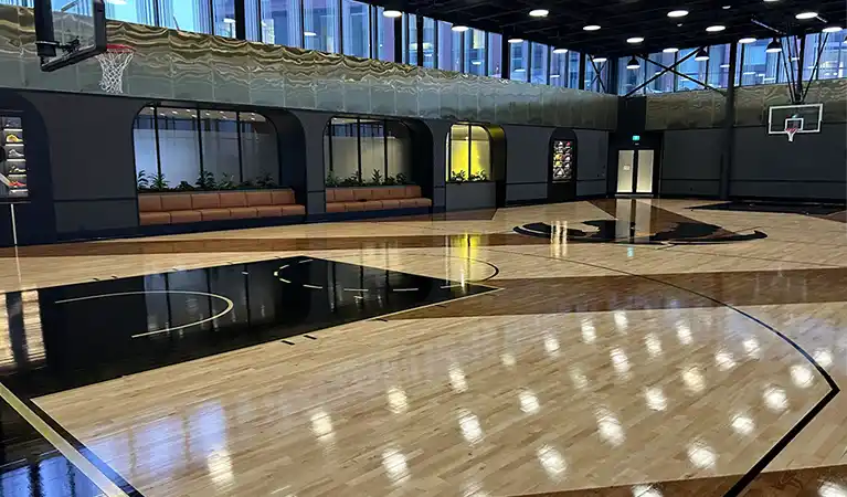 Full NBA-sized Junckers UnoBat 45 hardwood basketball court with custom chevron pattern at Sloane Building, North York.