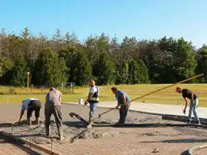 Pouring concrete foundation for outdoor multigame court installation in Breslau Ontario