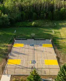 modular backyard basketball court in Toronto during fall with autumn leaves showing year-round durability and readiness for early spring play