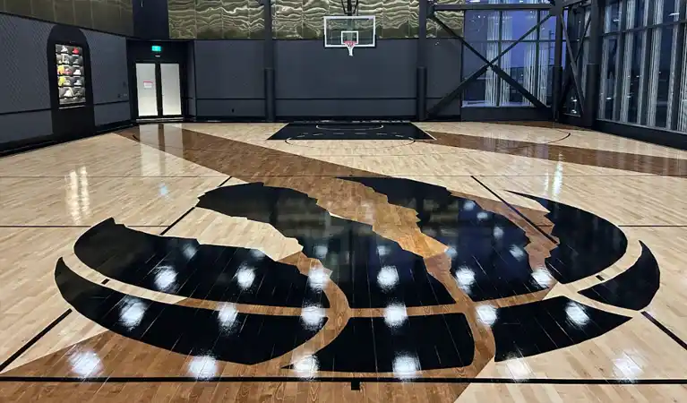 20-foot custom Toronto Raptors centre court logo integrated into a Junckers hardwood floor with a custom chevron stain pattern.