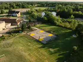 This huge 70' by 100' sports complex features multiple hoops and full containment, serving as the central outdoor athletic hub for the Breslau campus.