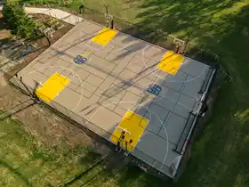 This massive 70' by 100' court features custom logos, multi-game lines for tennis and basketball, and full containment, providing endless options for students.