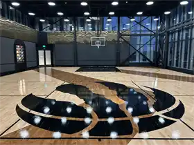 A closer look at the center court. TSS executed a complex, custom-stained logo design that serves as the room's centerpiece, demonstrating the versatility and design potential of the Junckers solid hardwood system.