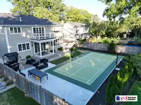 This medium 26' by 50' multi-game court in Burlington provides the perfect space for family pickleball, volleyball, basketball and tennis, blending seamlessly with the backyard landscape.
