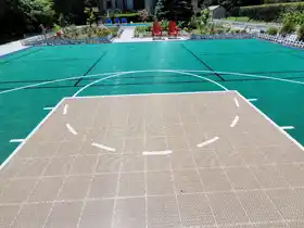 This 20' x 43' backyard basketball court in Burlington features SnapSports® athletic surfaces in a custom green and tan color scheme. This professional-grade residential installation provides a durable, high-performance area for families to stay healthy and play together.