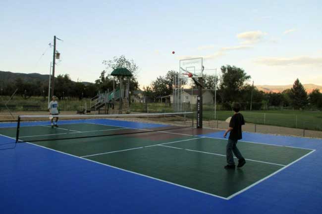 Kids playing pickleball in an oudoor court